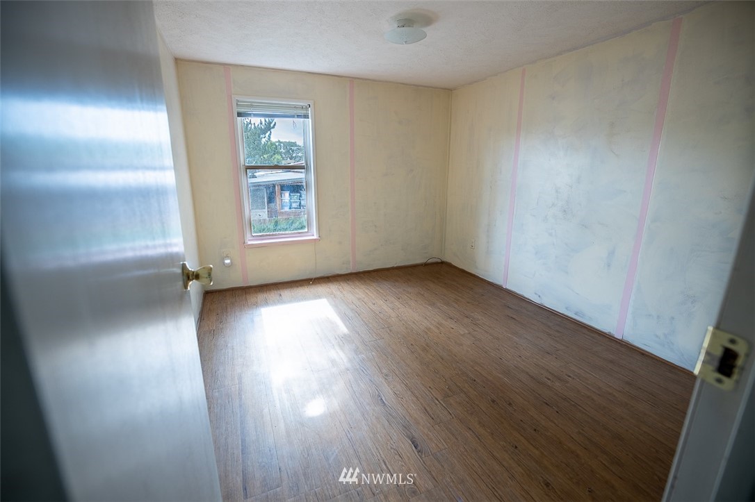373 Conconully Road Okanogan, WA 98840 - Photo 12 of 24 an empty room with wooden floor and windows