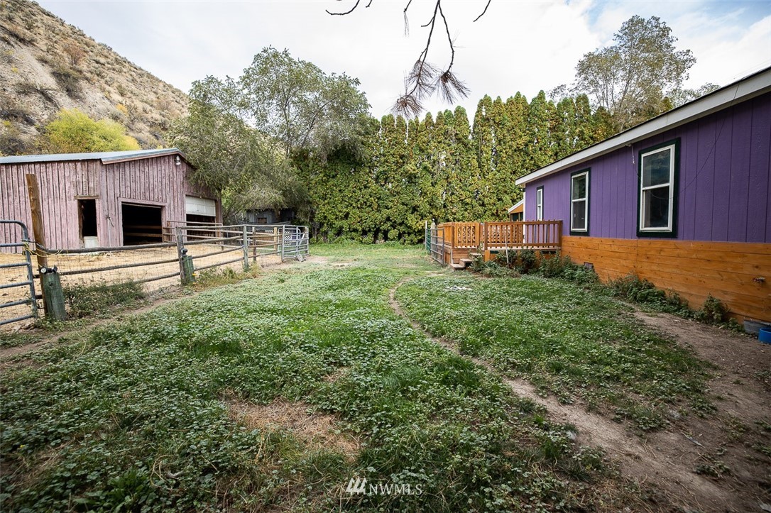 373 Conconully Road Okanogan, WA 98840 - Photo 20 of 24 a backyard of a house with wooden fence and large trees