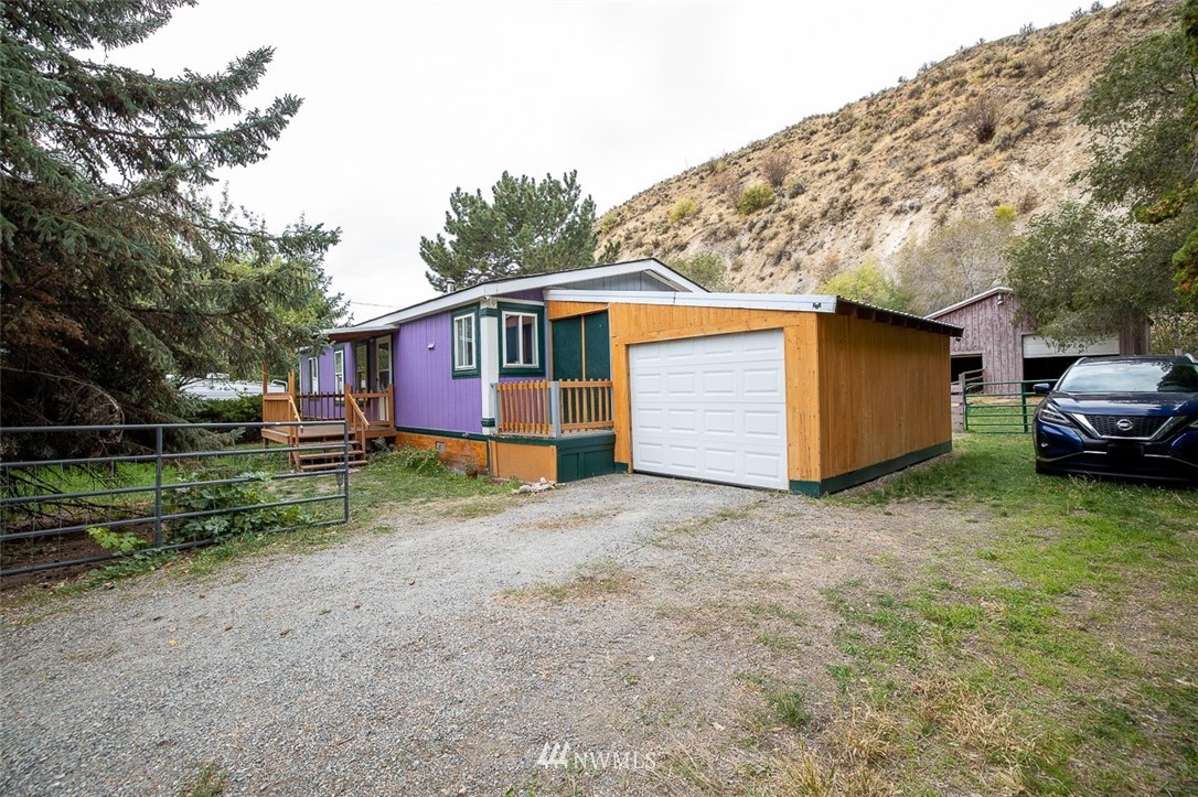 373 Conconully Road Okanogan, WA 98840 - Photo 5 of 24 a front view of a house with a yard and garage