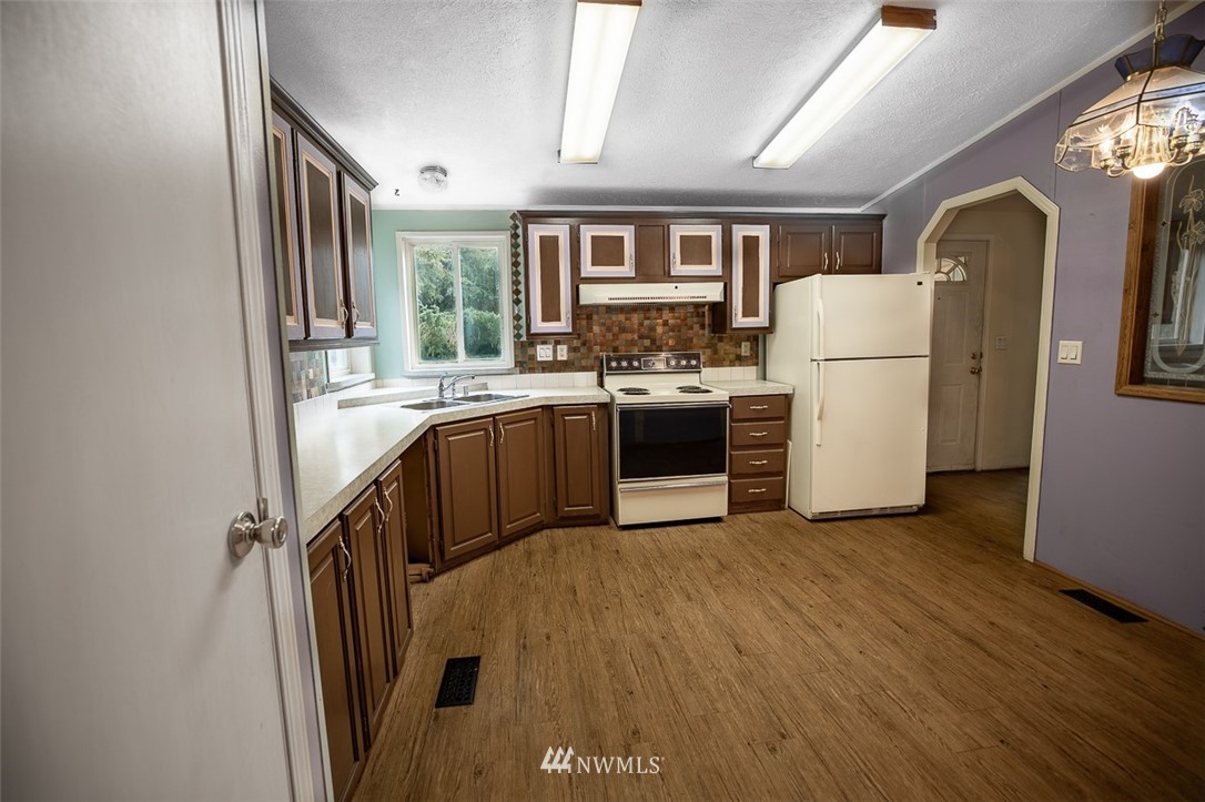 373 Conconully Road Okanogan, WA 98840 - Photo 6 of 24 a kitchen with a refrigerator a stove top oven and a sink