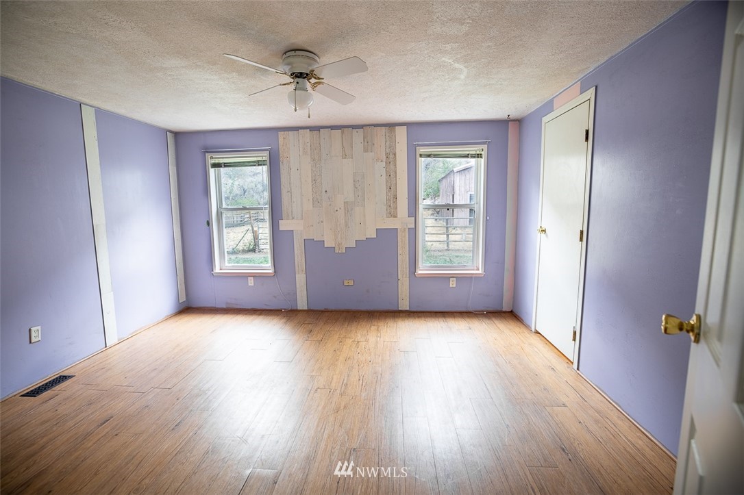 373 Conconully Road Okanogan, WA 98840 - Photo 10 of 24 an empty room with wooden floor and windows