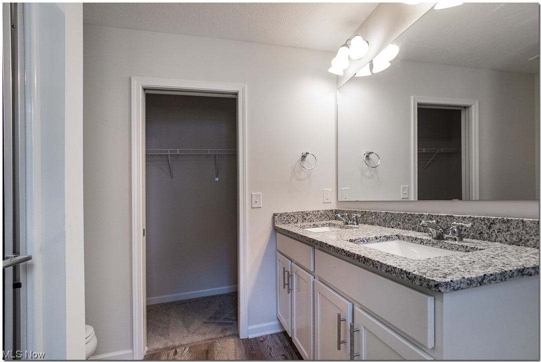7701 Webster Road Middleburg Heights, OH 44130 - Photo 10 of 29 Bathroom with wood-type flooring, large vanity, toilet, and double sink