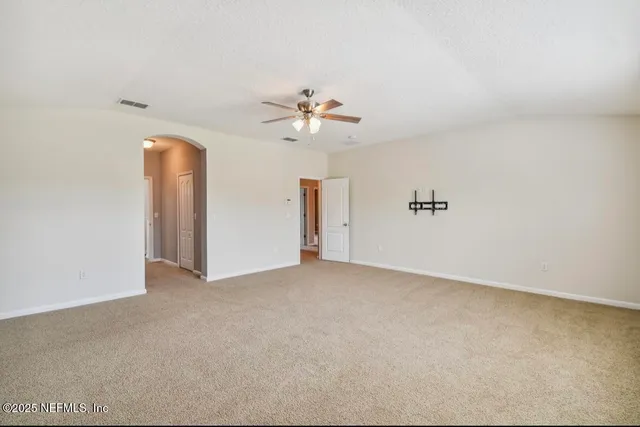 an empty room with a ceiling fan and a window