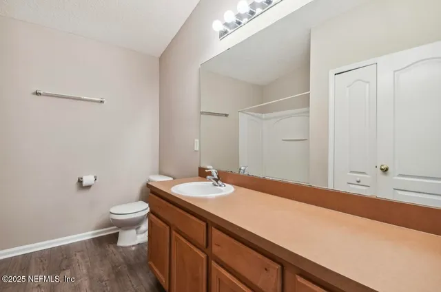 a bathroom with a sink a toilet and a large mirror