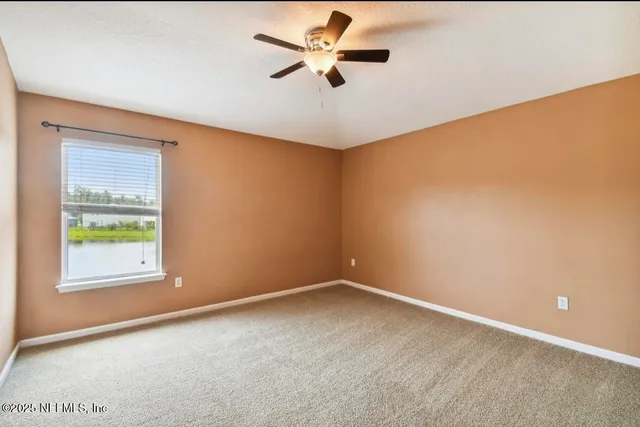 an empty room with a window and a fan