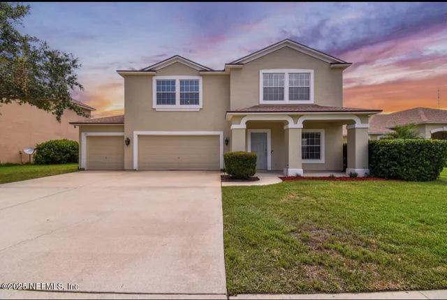a front view of a house with a yard and garage