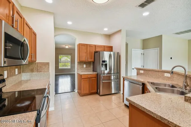 a kitchen with stainless steel appliances granite countertop a refrigerator and a stove top oven
