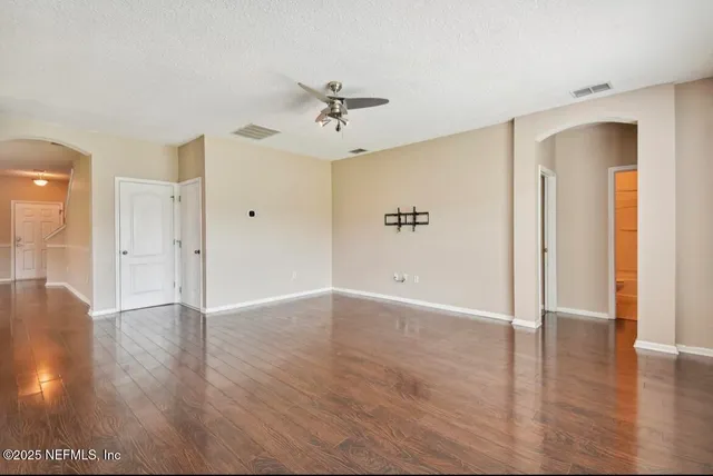 a view of a livingroom with wooden floor and a ceiling fan