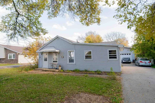 a front view of house with yard and trees around