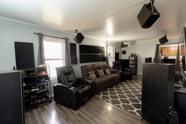 a living room with furniture a flat screen tv and wooden floor