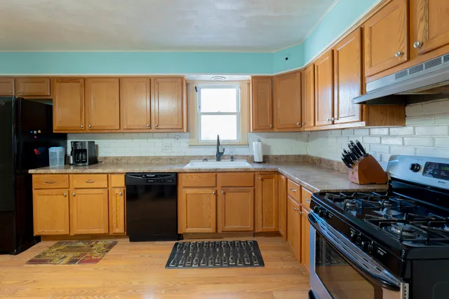 a kitchen with granite countertop a sink stove and cabinets