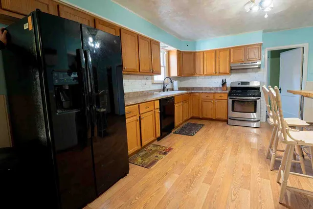 a kitchen with stainless steel appliances a refrigerator sink and cabinets