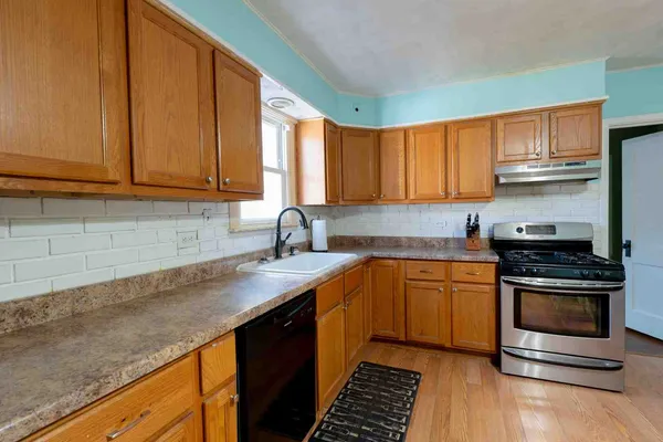 a kitchen with stainless steel appliances granite countertop a sink stove and cabinets