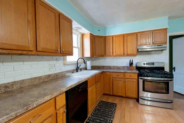 a kitchen with stainless steel appliances granite countertop a sink stove and cabinets