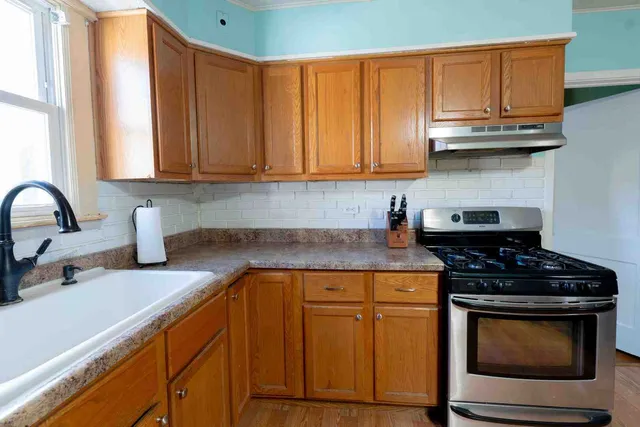 a kitchen with granite countertop wood cabinets and stainless steel appliances