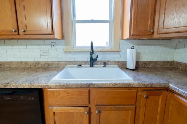 a kitchen with granite countertop white cabinets and a sink
