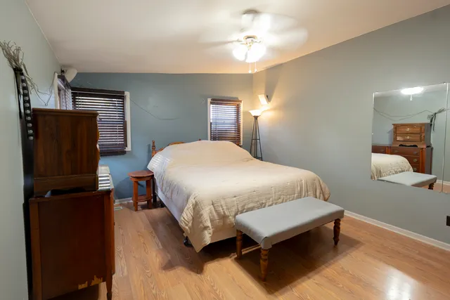 a bedroom with a bed window and dresser