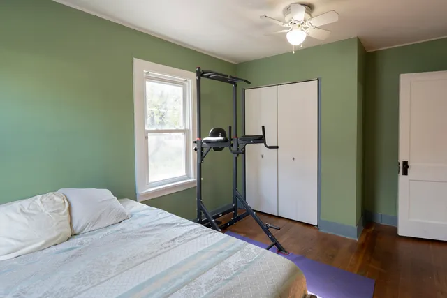 a bedroom with a bed and wooden floor
