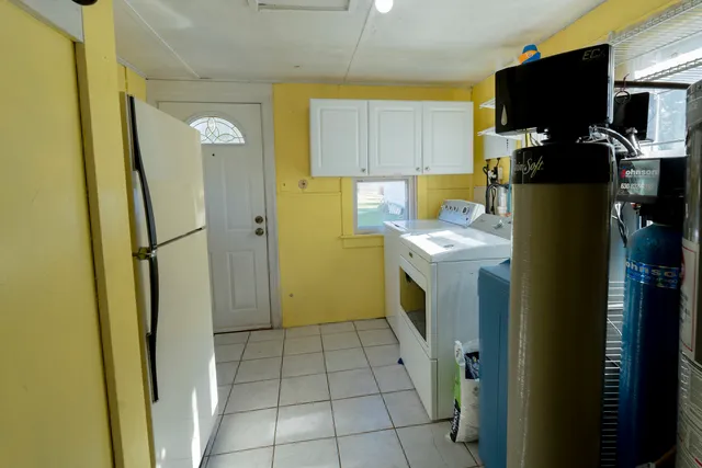 a view of a kitchen with fridge and wooden floor