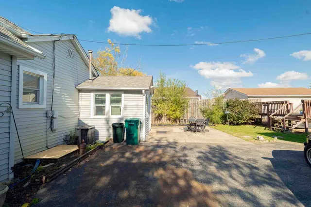 a backyard of a house with barbeque oven table and chairs