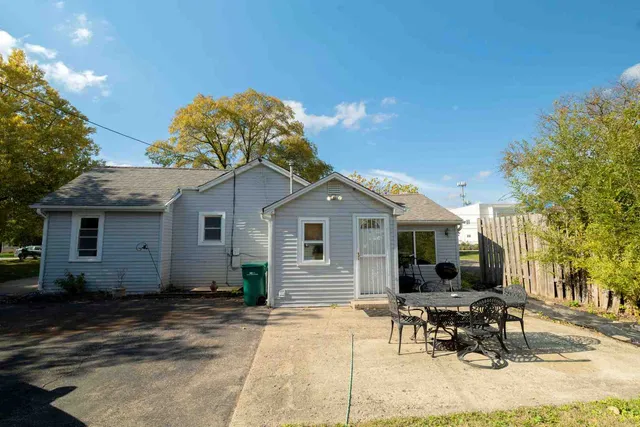 a backyard of a house with table and chairs