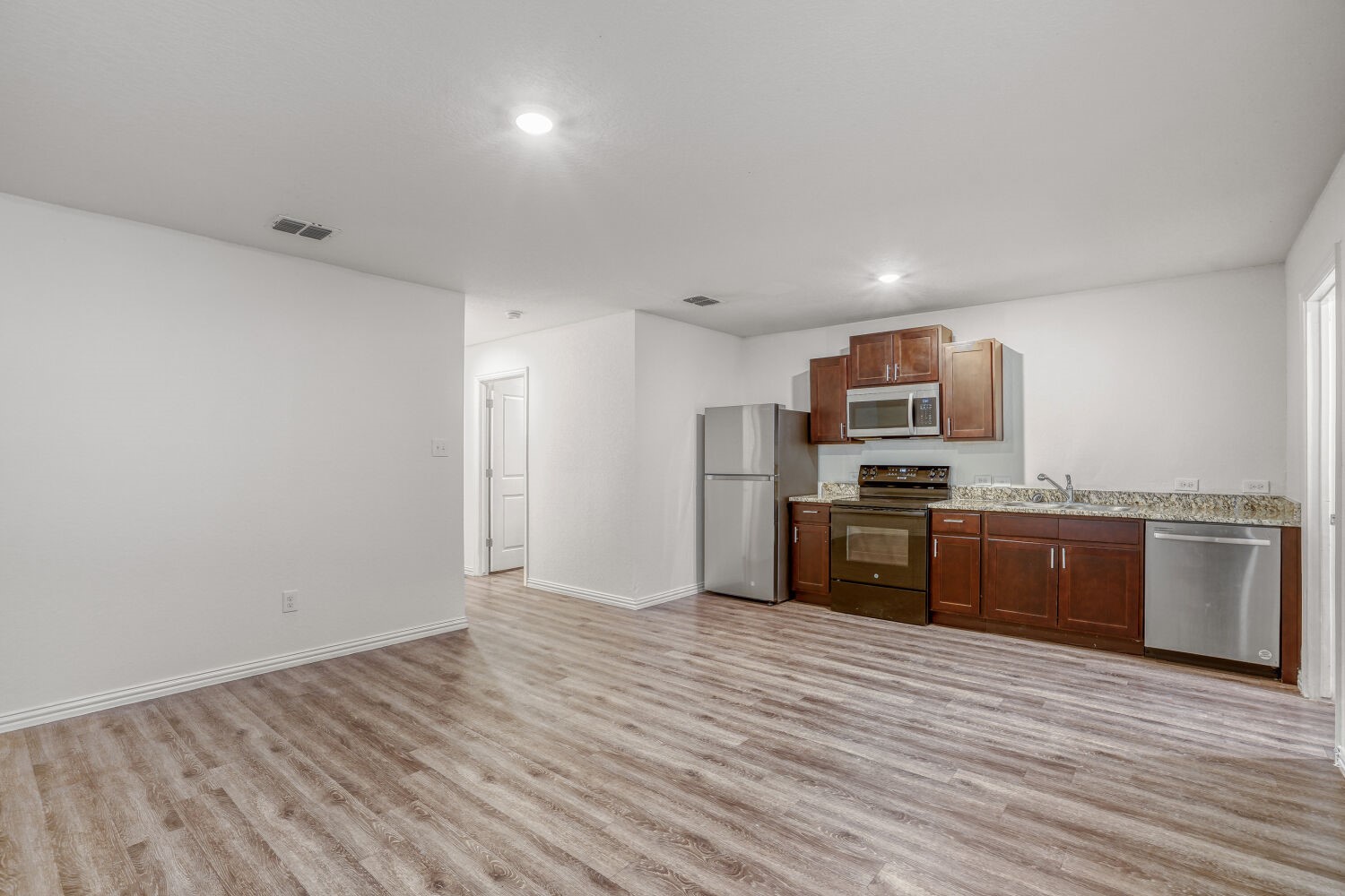 5626 Simsdale Street Houston, TX 77033 - Photo 2 of 10 a kitchen with stainless steel appliances a refrigerator and a stove top oven
