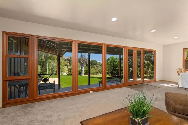 a spacious bedroom with a bed painting on wall and a large window