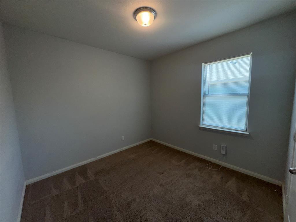 14360 Riata Lane Dallas, TX 75253 - Photo 12 of 16 Bright secondary bedroom featuring neutral wall finishes, wood-finish carpeting, a single-hung window with natural light, and recessed ceiling lighting
