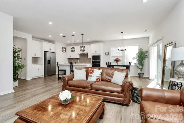 a living room with furniture and a dining table with wooden floor
