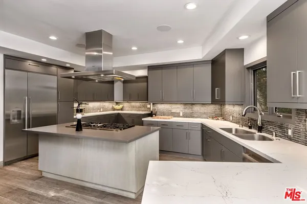 a kitchen with a sink stainless steel appliances and view living room