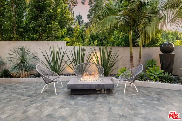 a view of a chairs and table in the backyard of a house