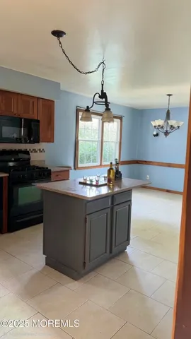 a kitchen with kitchen island granite countertop a sink window and refrigerator