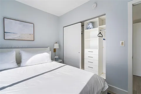 a bedroom with a bed and a mirror