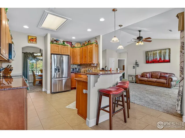 a living room with stainless steel appliances kitchen island granite countertop furniture and a couch