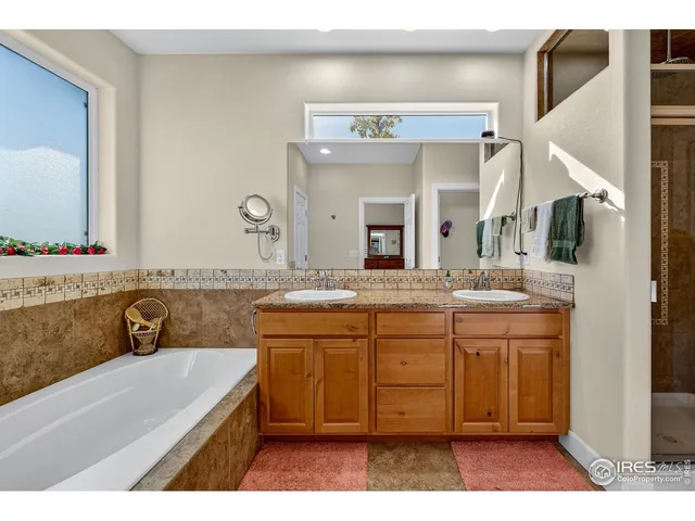 a bathroom with a tub a sink and mirror