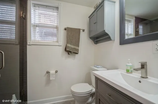 a bathroom with a sink a toilet and a mirror