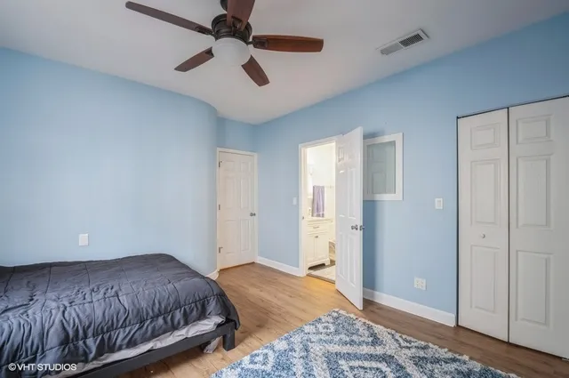 a spacious bedroom with a bed and a ceiling fan