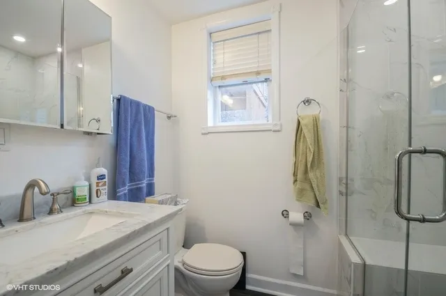 a bathroom with a granite countertop sink toilet and shower