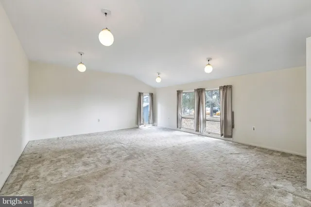 a view of an empty room with window and cabinet