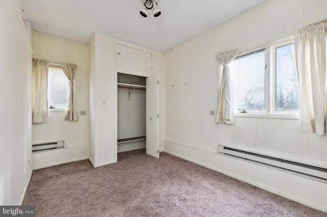 a view of a livingroom with wooden floor and a bathroom