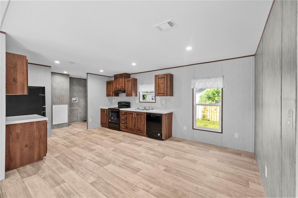 9160 Southwest 31st Avenue Road Ocala, FL 34476 - Photo 8 of 30 a large white kitchen with kitchen island a sink wooden floor and a refrigerator