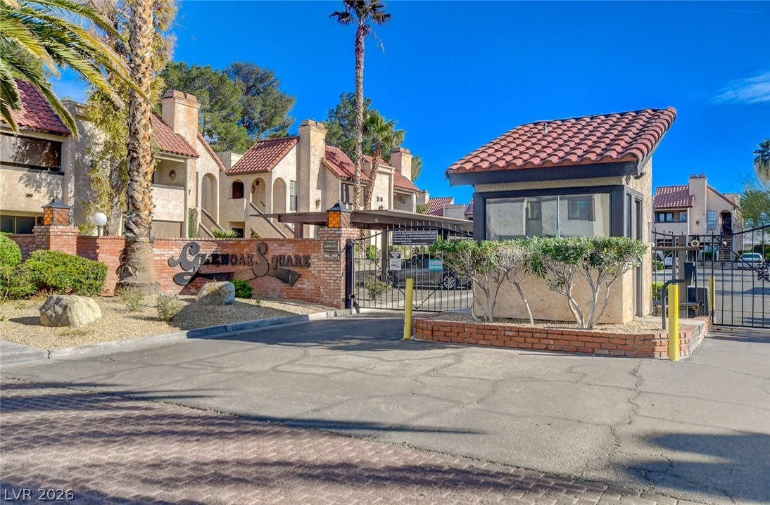 1751 East Reno Avenue, Unit 228 Las Vegas, NV 89119 - Photo 37 of 39 Secure community entrance with wrought iron gates and a guard station ensures privacy and controlled access.