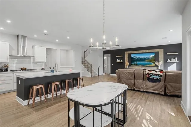 a living room with stainless steel appliances kitchen island granite countertop a dining table chairs and a kitchen view