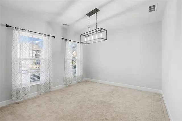 en empty room with windows and ceiling fan