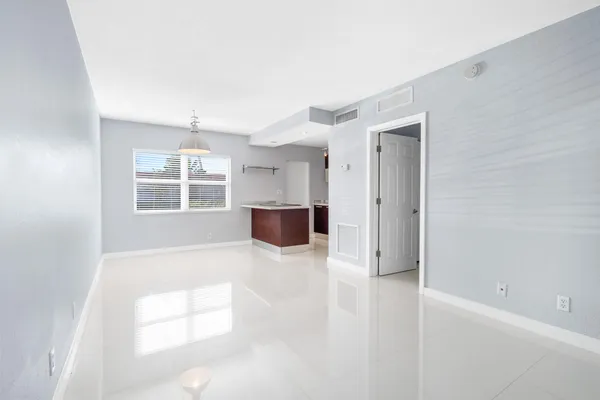 an empty room with windows and cabinet