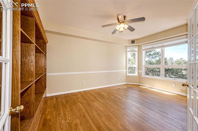 19340 Furrow Road Monument, CO 80132 - Photo 22 of 50 Empty room featuring baseboards, visible vents, wood finished floors, and a ceiling fan