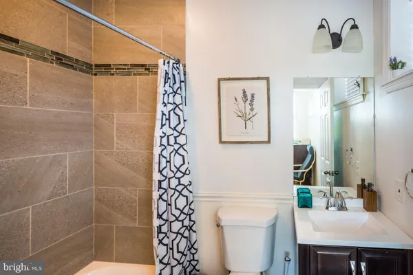 a bathroom with a shower a sink and a toilet