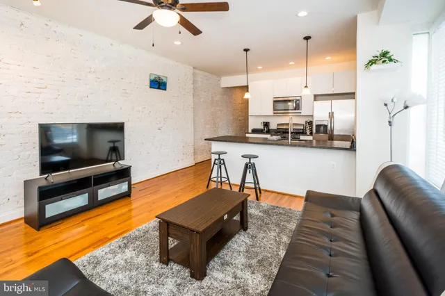 a living room with furniture kitchen view and a flat screen tv