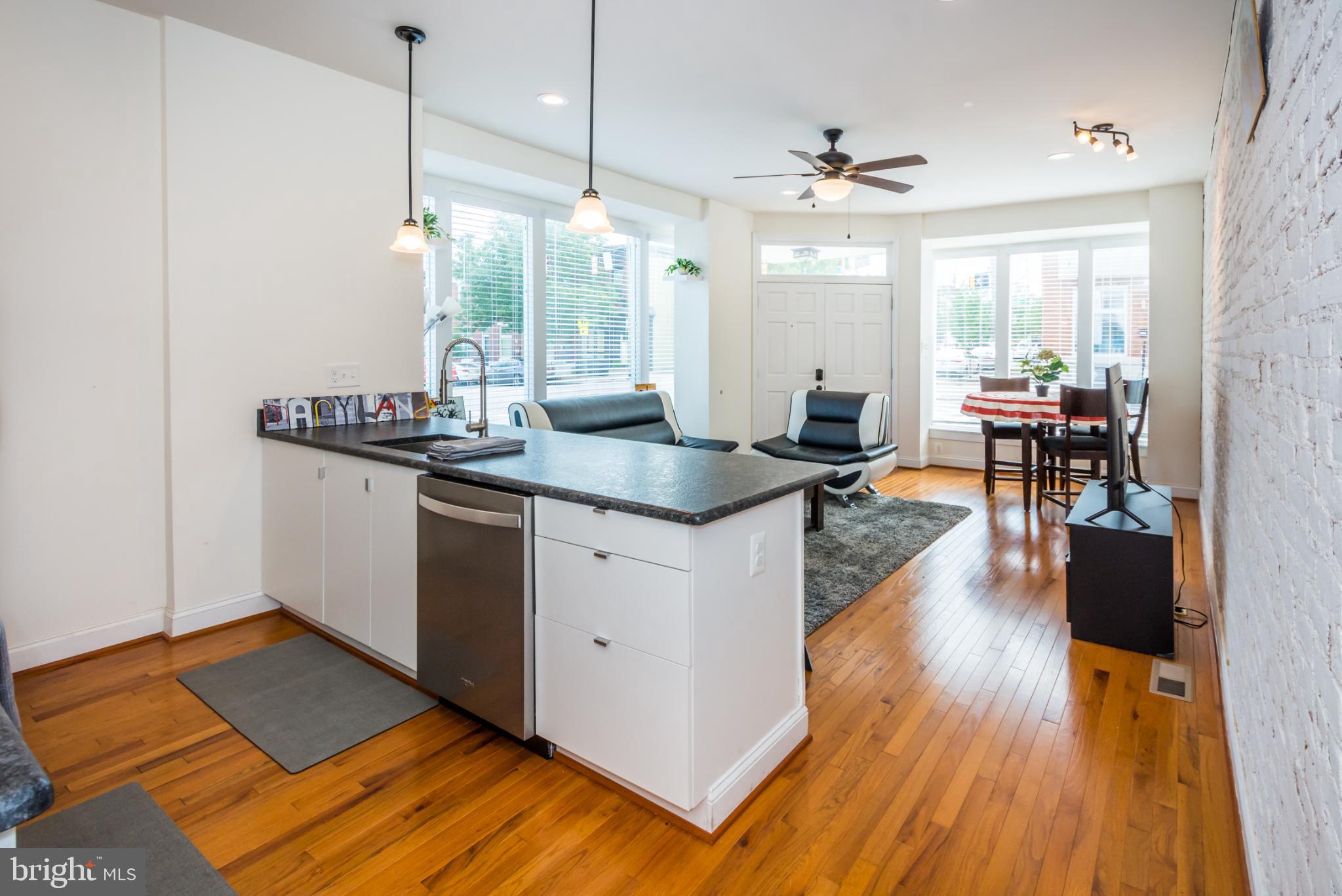 600 South Linwood Avenue, Unit A Baltimore, MD 21224 - Photo 8 of 33 a kitchen with stainless steel appliances granite countertop wooden floors and view of living room