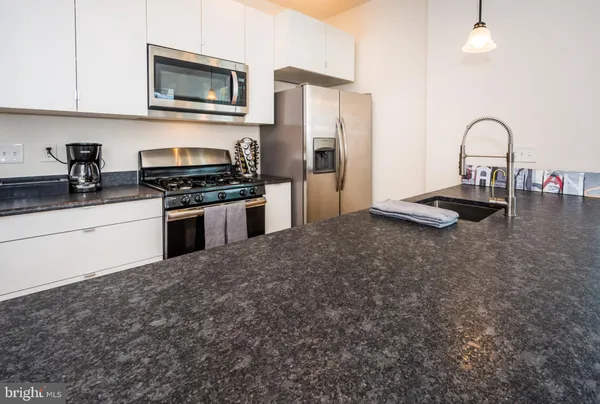a kitchen with stainless steel appliances granite countertop a sink and a stove top oven